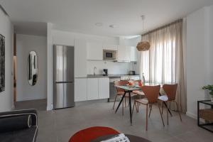 a kitchen and living room with a table and chairs at Royal Flats in Las Palmas de Gran Canaria