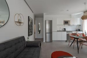 a living room with a couch and a kitchen at Royal Flats in Las Palmas de Gran Canaria