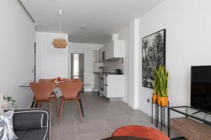 a living room with a table and chairs and a kitchen at Royal Flats in Las Palmas de Gran Canaria