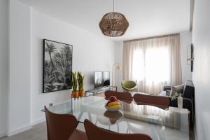 a living room with a glass table and chairs at Royal Flats in Las Palmas de Gran Canaria