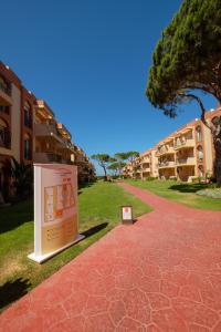 um sinal na relva ao lado de um edifício em Aparthotel las Dunas em Chiclana de la Frontera