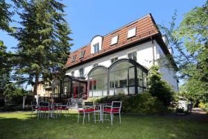 a patio with chairs and tables in front of a house at Hotel 7 Säulen GmbH in Dessau