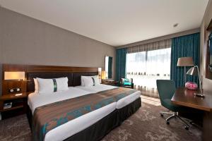 a bedroom with a large bed and a desk and a computer at Holiday Inn Nice by IHG in Nice +95 photos