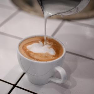 una taza de café con leche vertida en ella en Huskvarna Stadshotell en Huskvarna