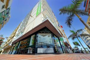 una tienda frente a un edificio con palmeras en Hotel Aloe Canteras, en Las Palmas de Gran Canaria