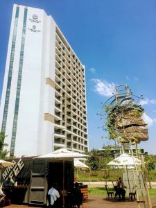a tall building with people sitting in front of it at The Residence Luxury Studio - Menlyn Maine in Pretoria