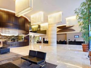 a lobby of a hotel with a chair in the middle at Novotel Citygate Hong Kong in Hong Kong