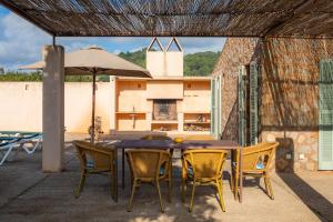 een tafel en stoelen en een parasol op een patio bij Pedra Viva in Son Servera