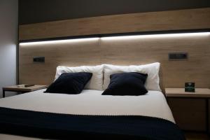 a large white bed with two pillows on it at Alda Centro Zaragoza in Zaragoza