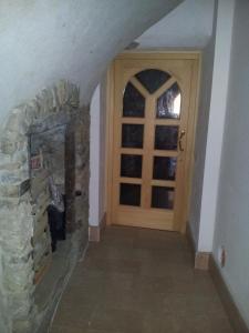 a hallway with a stone fireplace and a wooden door at La Cort Di Nonna Rosa in Mori