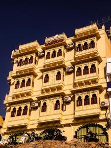 un edificio alto de color amarillo con balcones encima en Hotel Mewari Villa, en Udaipur