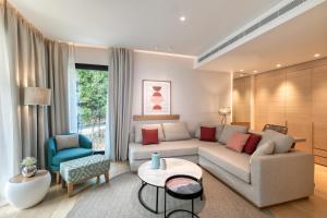 a living room with a couch and a table at Vathi Cove Luxury Resort & Spa in Chrysi Ammoudia