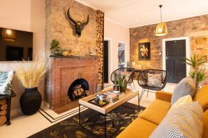 a living room with a brick wall and a fireplace at Thelma & You in Cape Town