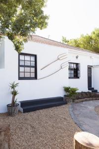 a white house with black windows and a driveway at Thelma & You in Cape Town