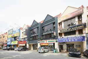 een stadsstraat met auto's geparkeerd voor gebouwen bij D'New 1 Hotel in Subang Jaya