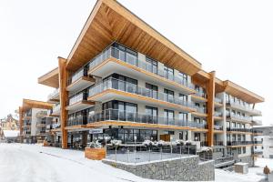 an apartment building in the winter with snow on the ground at Apartman Lucid C207 in Vysoke Tatry - Stary Smokovec