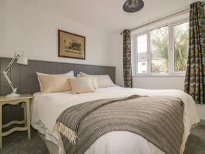 a bedroom with a large bed and a window at Crantock Lodge in Newquay