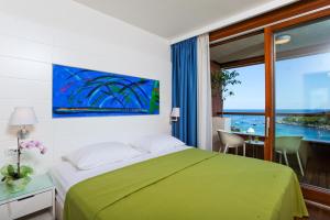 
a hotel room with a bed and a painting on the wall at All Suite Island Hotel Istra in Rovinj

