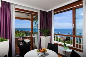 a room with a balcony with a view of the ocean at Maistra Select All Suite Island Hotel Istra in Rovinj