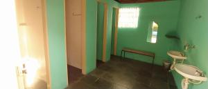 La salle de bains est pourvue de 2 toilettes et de murs verts. dans l'établissement Camping São Pedro - Área de acampamento dentro de Diamantina, à Diamantina