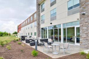 a building with chairs and tables outside of it at Holiday Inn Express & Suites Salem by IHG in Salem