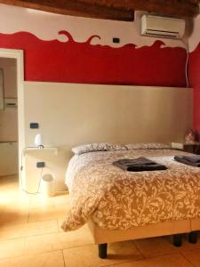um quarto com uma cama com uma parede vermelha em Terrazza Tassis Charme&Relax em Bérgamo