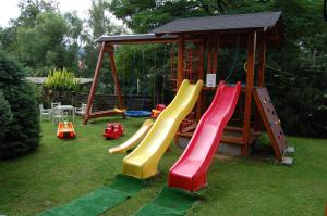 un parque infantil con toboganes coloridos y cenador en Apartments Hážovský Dvůr en Rožnov pod Radhoštěm