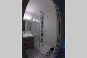 La salle de bains est pourvue d'une douche avec une guitare sur le mur. dans l'établissement Studio - 700m plage port - 200m golf - wifi - piscine, à Pornic