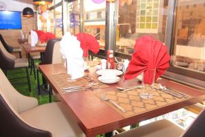 einen Tisch in einem Restaurant mit roten Servietten und Utensilien in der Unterkunft Vickmark Hotel in Nakuru