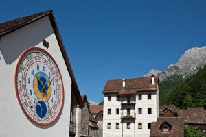 un reloj grande en el lateral de un edificio en Casa Pesarina, en Prato Carnico