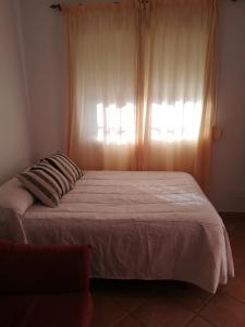 une chambre avec un grand lit avec une fenêtre dans l'établissement La Casa del Jazmín, à Benalmádena 8 autres photos