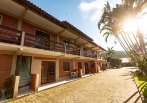 a building with a palm tree in front of it at Pousada Nossa Senhora de Fatima in Florianópolis