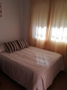 une chambre avec un grand lit avec une fenêtre dans l'établissement La Casa del Jazmín, à Benalmádena