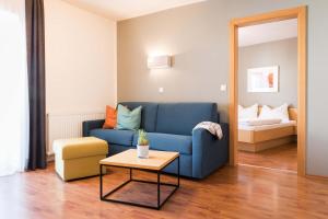 a living room with a blue couch and a table at Sankt Johann Spa Suites & Apartments in Prato allo Stelvio