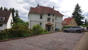 un coche aparcado frente a una casa blanca en Ferienwohnung Wäldle, en Bad Sachsa