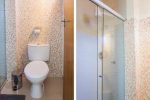 a bathroom with a toilet and a glass shower at OYO Hotel Brisa Tropical, Brasília in Brasília