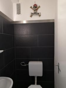 un bagno con parete piastrellata nera e insegna a predone di 3 Zimmer Wohnung in Eppelheim 77qm 1A Lage nähe Heidelberg a Eppelheim