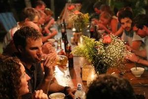a group of people sitting at a long table at Paredon Surf House in El Paredón Buena Vista