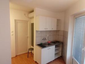 a kitchen with white cabinets and a sink at Veliki Park in Šabac