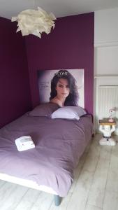 a bedroom with a bed with a poster on the wall at pour vos séjours pro ou détentes in Issoire +5 photos