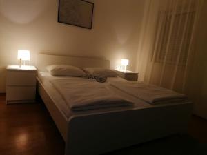 a bedroom with a bed with two lamps on it at Veliki Park in Šabac