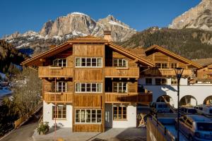 a large wooden house with mountains in the background at Chalet Corvara in Corvara in Badia