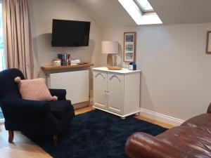 a living room with a couch and a tv at The Captains Quarters, Woolsery in Bideford