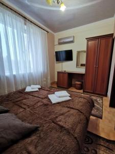 1 dormitorio con 1 cama grande y 2 toallas. en Monte-Kristo Hotel, en Kamianets-Podilskyi