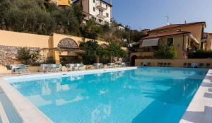 a large blue swimming pool next to a building at Hotel Della Baia in Portovenere