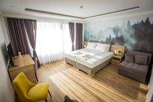 コパオニクにあるSREBRNA PLANINA Spa & Resortのベッドルーム1室(ベッド1台、ソファ、椅子付)