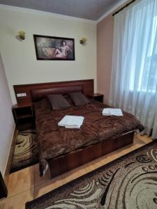 1 dormitorio con 1 cama con 2 toallas en Monte-Kristo Hotel, en Kamianets-Podilskyi