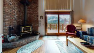 a living room with a fireplace and a brick wall at Meadow Ridge #28 condo in Mammoth Lakes