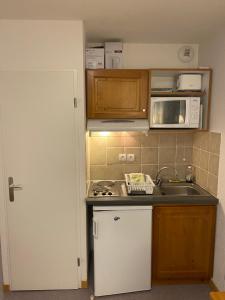 a small kitchen with a sink and a microwave at Studio les toits du Devoluy in Le Dévoluy