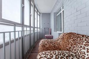 a room with a leopard print couch and windows at Welcome Home Apartments Dalnevostochnaya 106 in Irkutsk